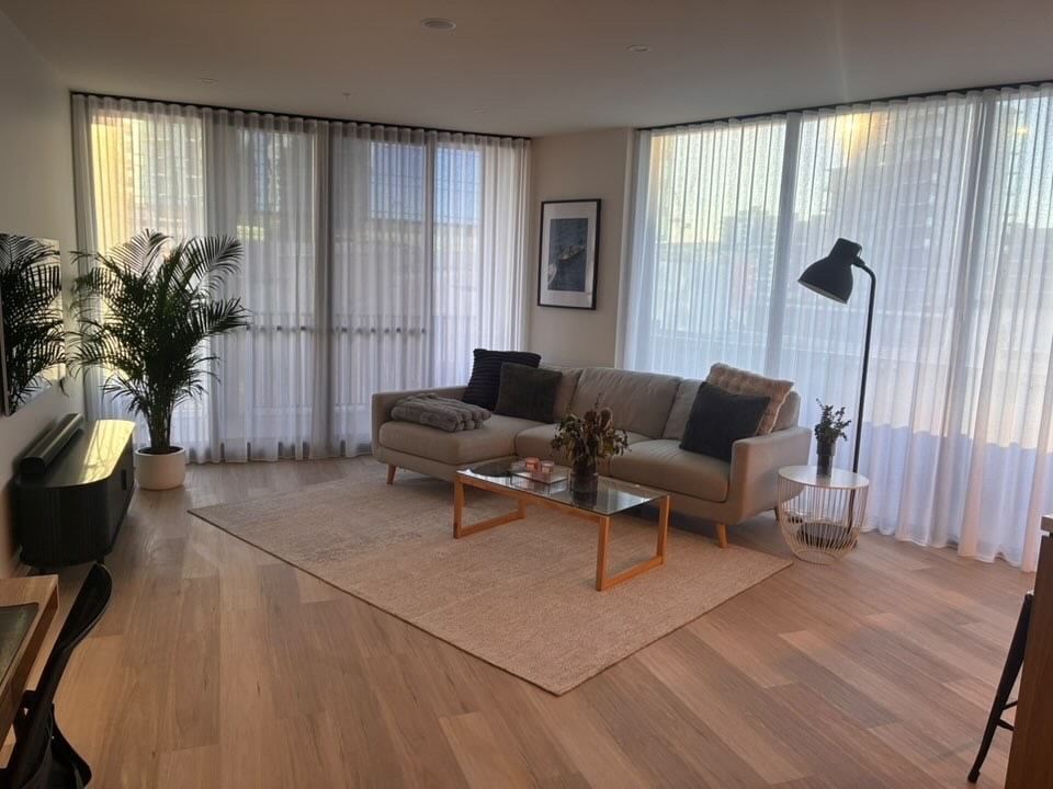 Bright, freshly cleaned modern living room with sheer curtains and natural light